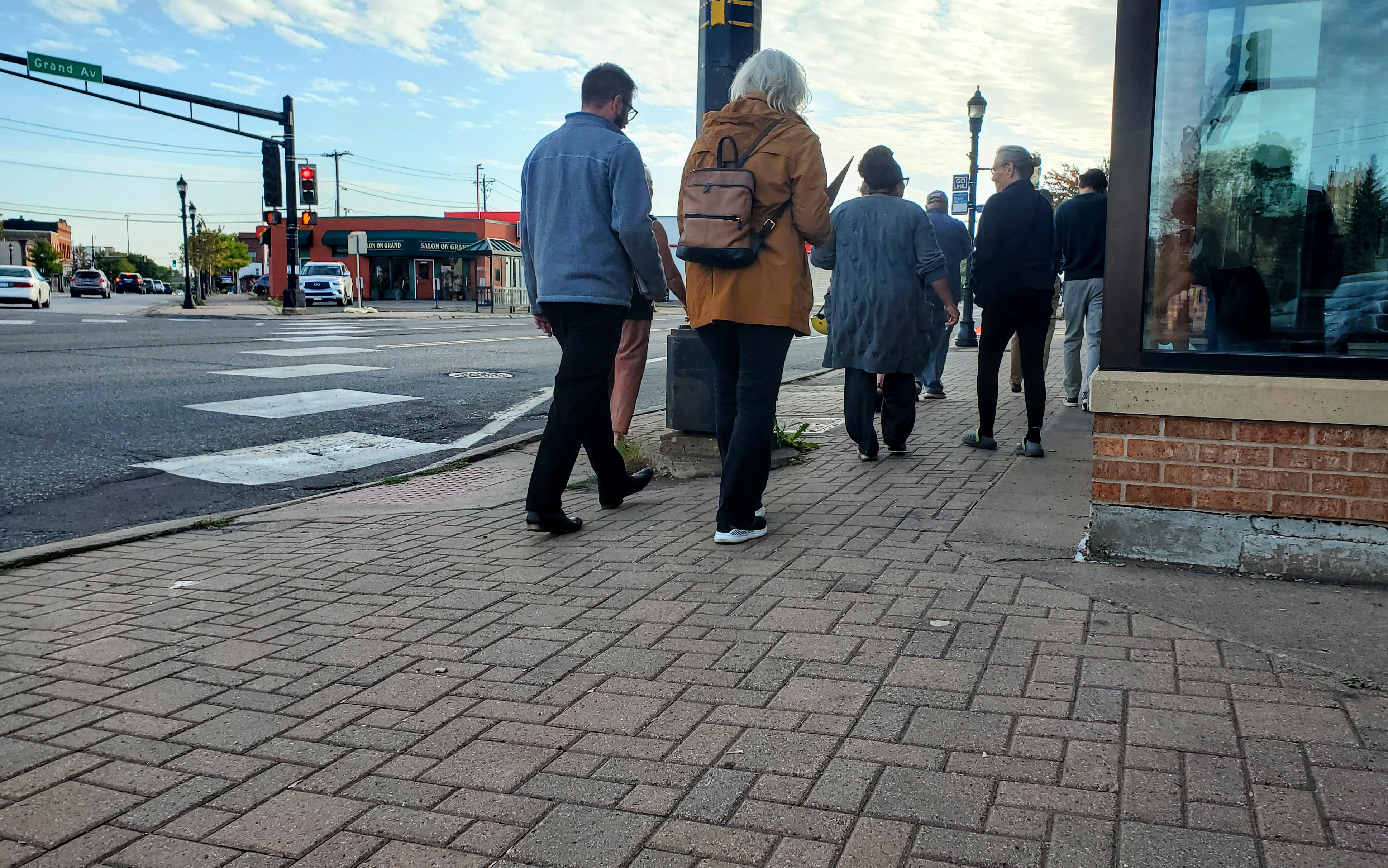 A photo of people walking on the Grand Ave. sidewalk during the Spirit Valley Stroll.
